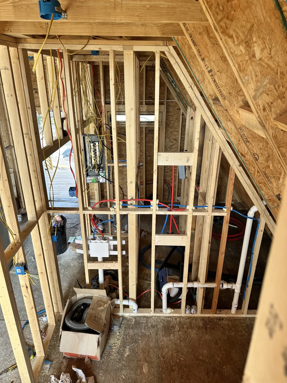 Plumbing and electrical rough-in between open wall studs.